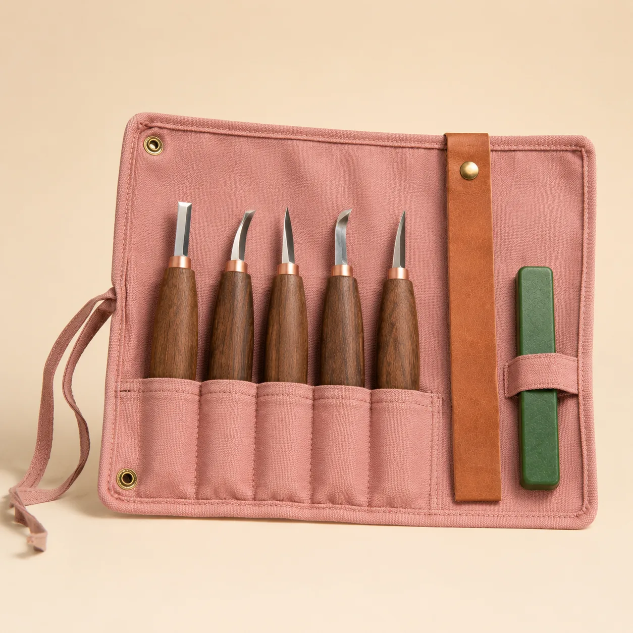 The open canvas roll photographed against a plain warm background, five walnut handles in their slots with the green polishing wax alongside