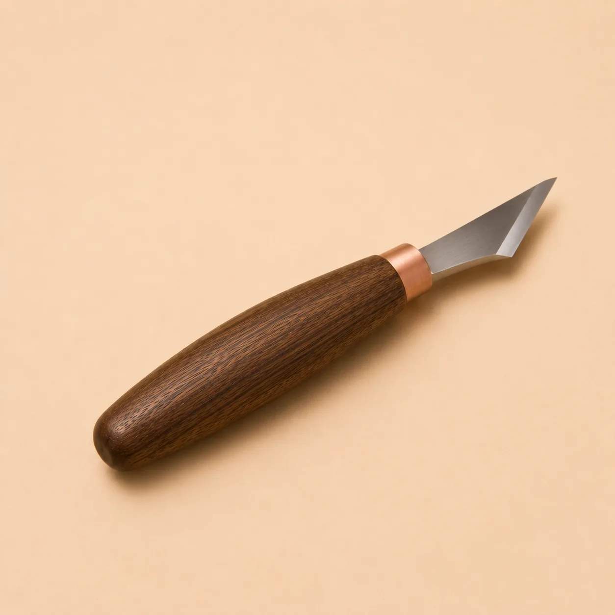 The chip carving knife photographed alone, its short bevelled blade seated in a walnut handle