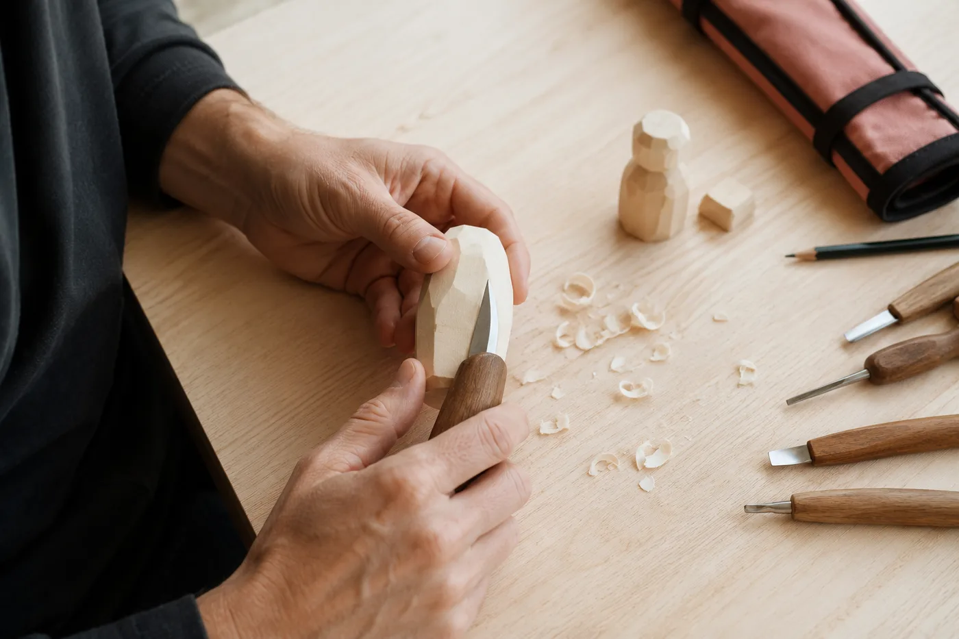 A beginner making a first cut into a pale basswood block with a walnut carving knife on a tidy table
